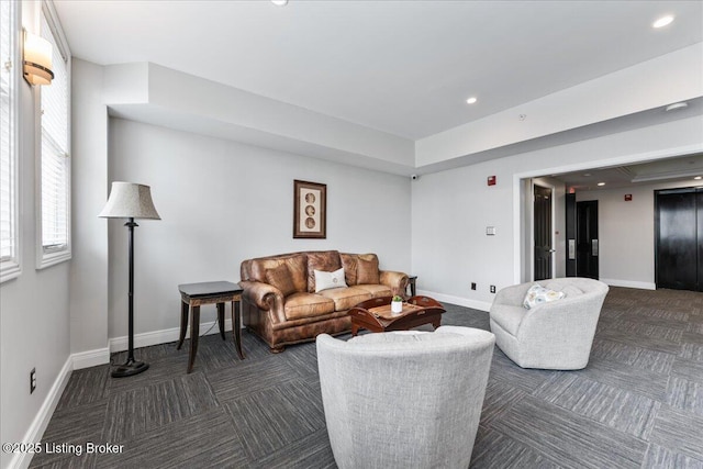 carpeted living room with recessed lighting, baseboards, and elevator