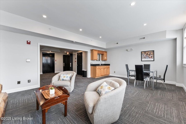 living room featuring recessed lighting, dark carpet, visible vents, and baseboards