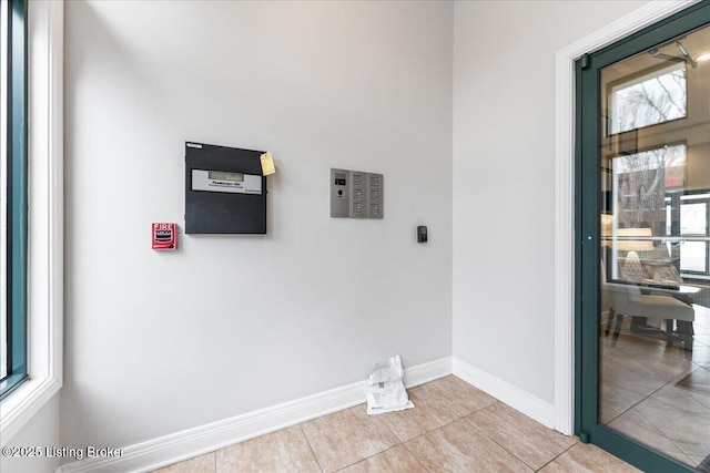 washroom featuring tile patterned floors, baseboards, and a healthy amount of sunlight