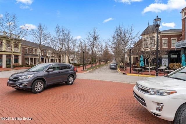 view of street featuring a residential view, curbs, street lights, and sidewalks