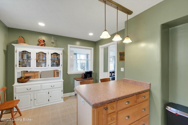 kitchen with baseboards, recessed lighting, glass insert cabinets, pendant lighting, and white cabinetry