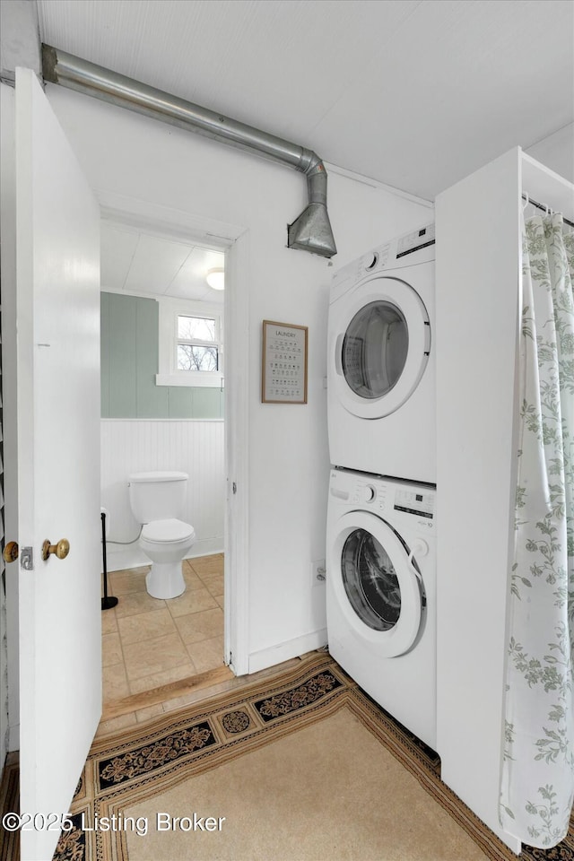 laundry area with laundry area, stacked washer and dryer, and tile patterned floors