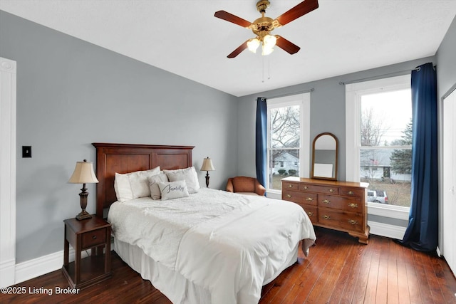 bedroom with ceiling fan, baseboards, and dark wood-style flooring