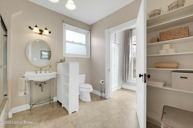 bathroom featuring toilet and baseboards