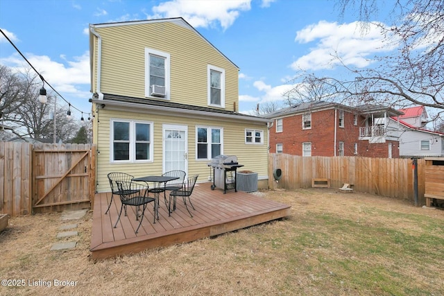 rear view of house with a gate, a fenced backyard, cooling unit, a yard, and a wooden deck