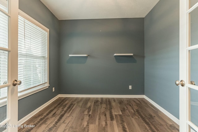 empty room featuring french doors, wood finished floors, and baseboards