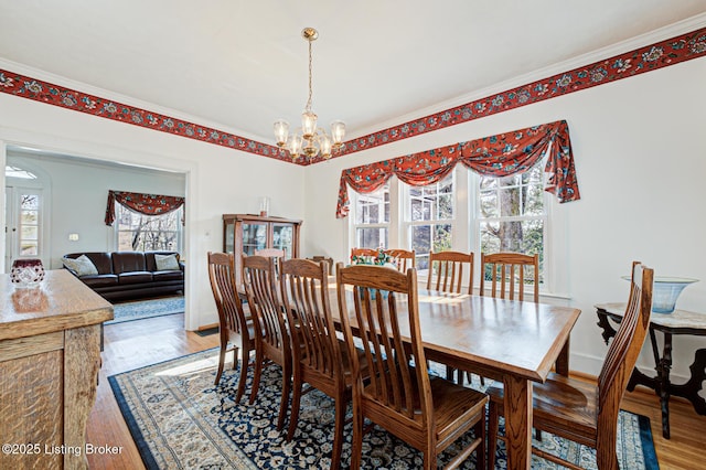 dining room with baseboards, light wood-style flooring, and a chandelier