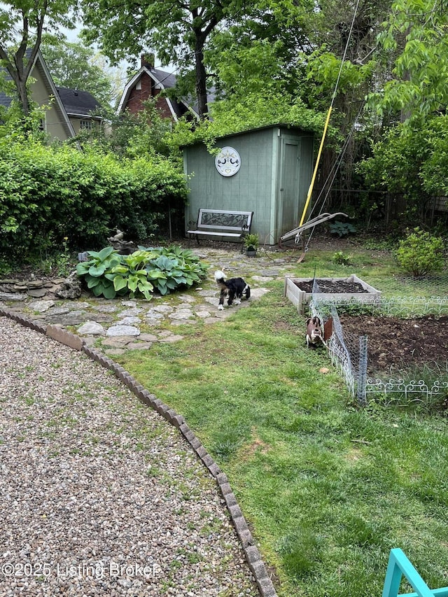 view of yard with a garden, an outdoor structure, and a shed