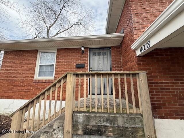 doorway to property featuring brick siding