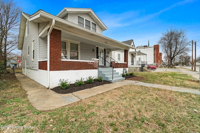 view of front of house featuring a front lawn and brick siding