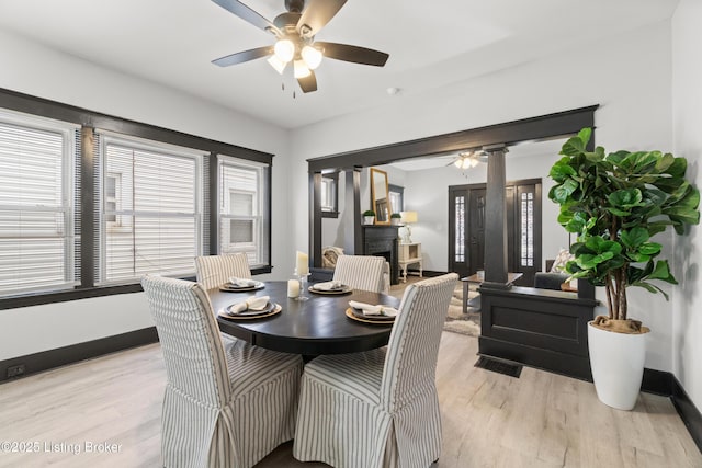 dining room featuring light wood-style floors, baseboards, and a wealth of natural light