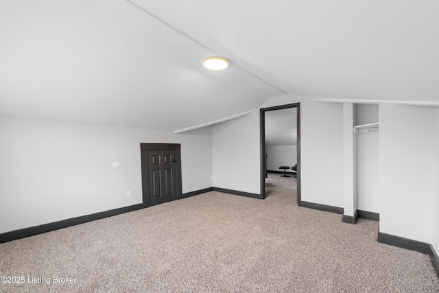 additional living space with vaulted ceiling, carpet, and baseboards