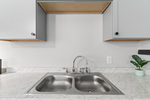 details with white cabinets, light countertops, and a sink