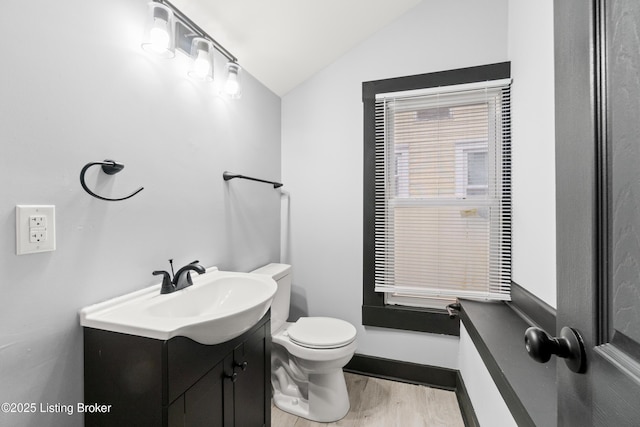 bathroom featuring lofted ceiling, vanity, toilet, and wood finished floors