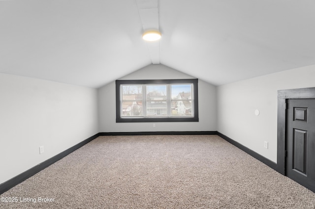 bonus room featuring vaulted ceiling, carpet, and baseboards