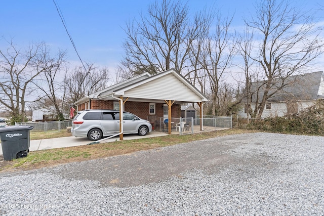 view of front of house with brick siding, fence, and driveway