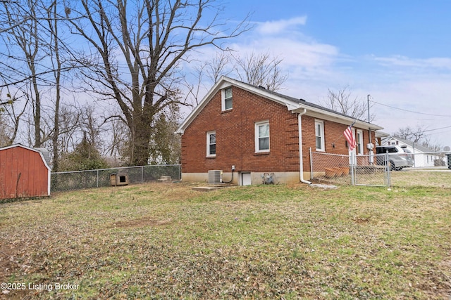 view of home's exterior featuring brick siding, a lawn, a fenced backyard, and a gate