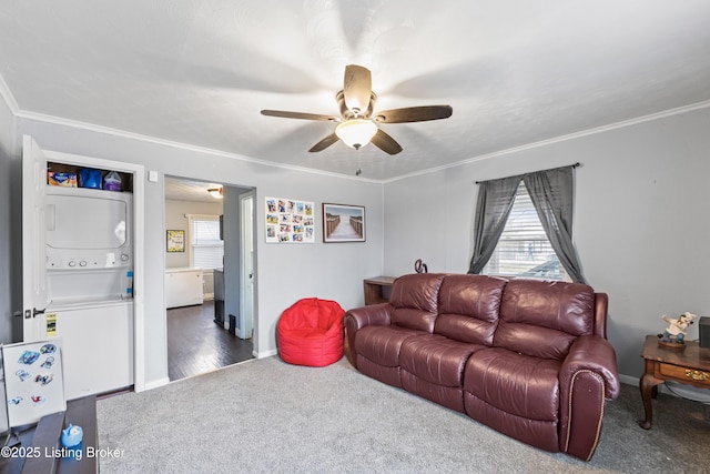 carpeted living room featuring stacked washer / drying machine, a healthy amount of sunlight, and crown molding