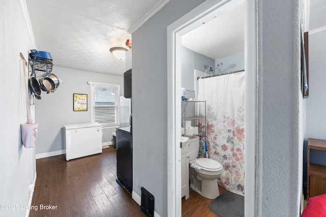 full bathroom featuring curtained shower, wood-type flooring, and baseboards