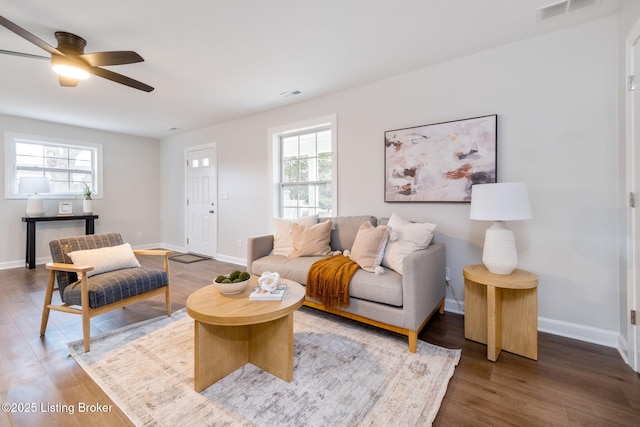 living area featuring wood finished floors, visible vents, and baseboards