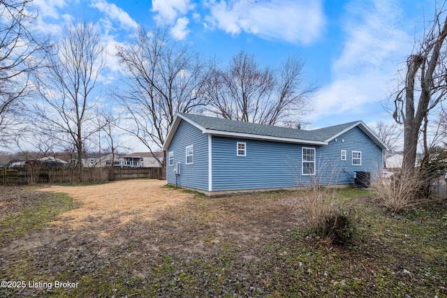 back of property featuring roof with shingles and fence