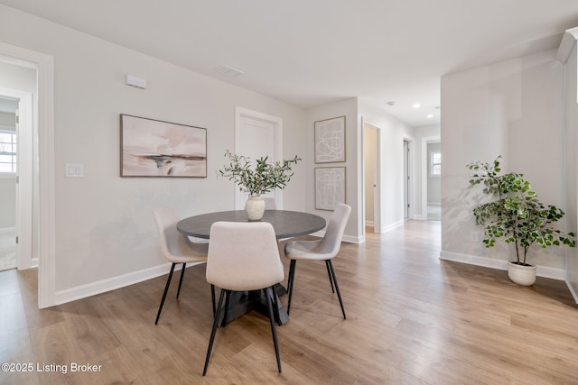 dining room featuring a wealth of natural light, baseboards, and light wood finished floors