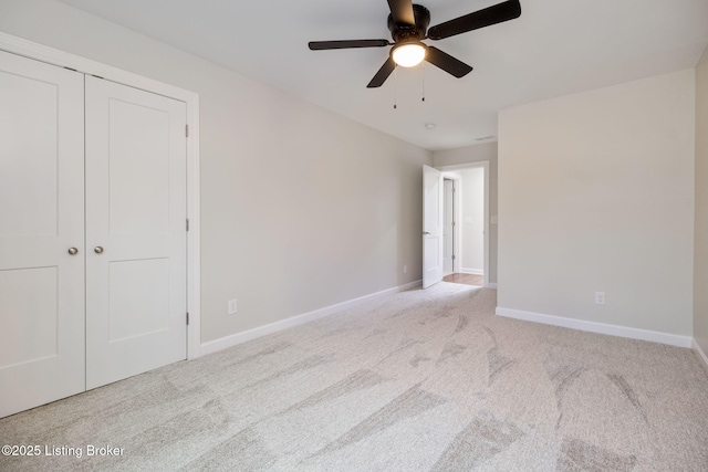 unfurnished bedroom featuring a closet, carpet flooring, a ceiling fan, and baseboards