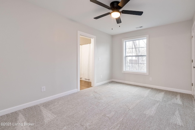 carpeted empty room featuring visible vents, baseboards, and a ceiling fan