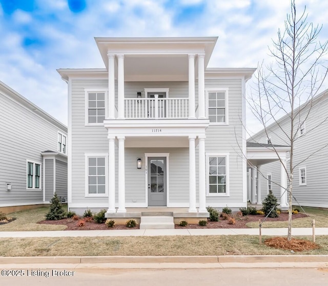 neoclassical home featuring a balcony