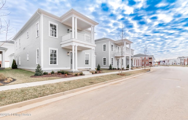 greek revival inspired property featuring a residential view and a balcony