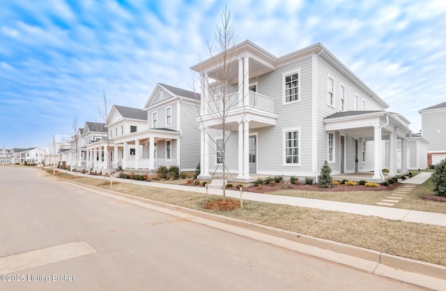 view of front facade featuring a balcony, a residential view, and a porch