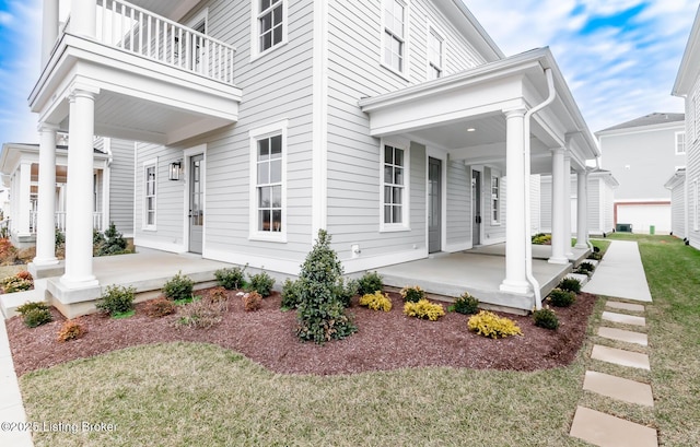 doorway to property with covered porch and a balcony