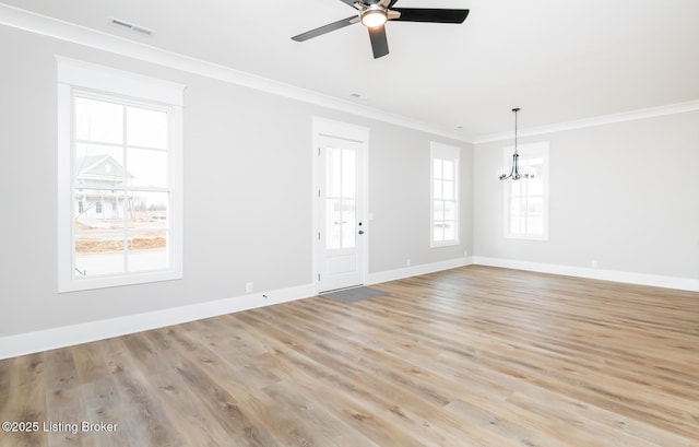 spare room featuring baseboards, visible vents, ornamental molding, light wood-type flooring, and ceiling fan with notable chandelier