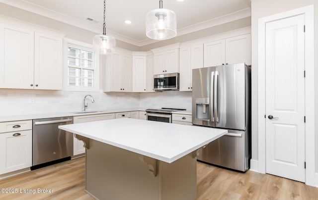 kitchen with ornamental molding, appliances with stainless steel finishes, a kitchen bar, and a sink