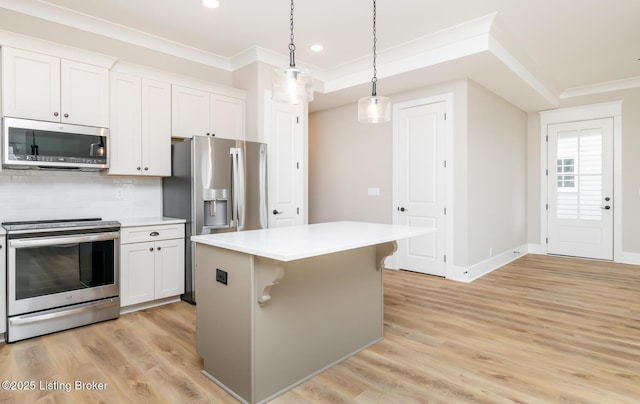 kitchen with ornamental molding, appliances with stainless steel finishes, light wood finished floors, and backsplash