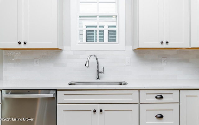 kitchen featuring dishwasher, light countertops, a sink, and white cabinetry