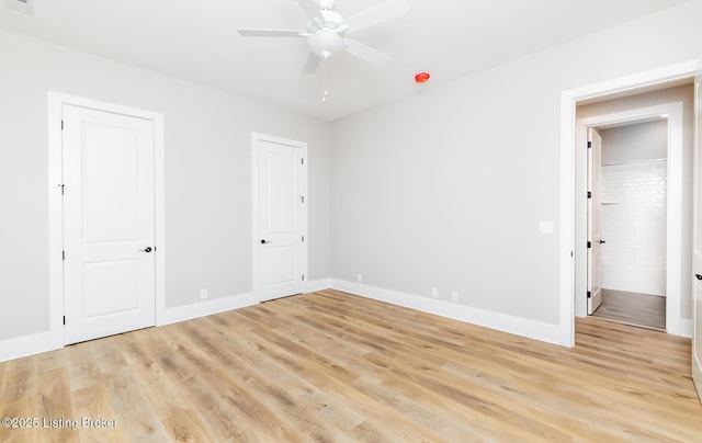 unfurnished bedroom featuring ceiling fan, light wood-style flooring, and baseboards