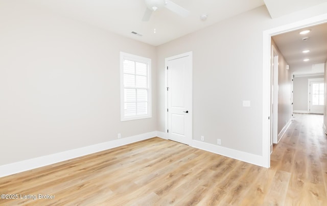 unfurnished room featuring visible vents, ceiling fan, light wood finished floors, and baseboards