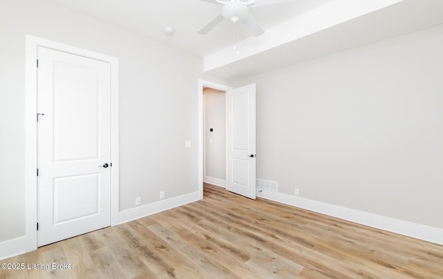 empty room featuring ceiling fan, light wood-type flooring, and baseboards