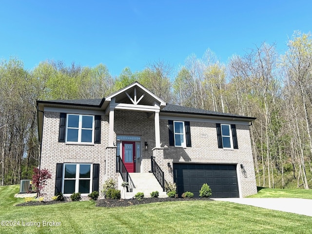 split foyer home with brick siding, driveway, central AC, and a front yard