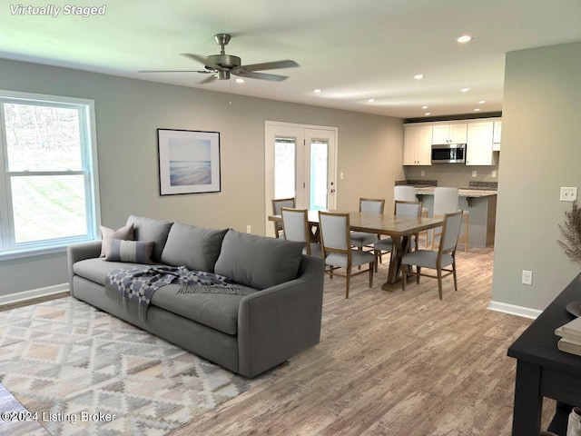 living room featuring ceiling fan, recessed lighting, light wood-type flooring, and baseboards