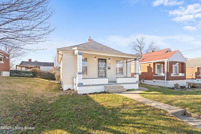 bungalow-style house with a porch, a chimney, and a front lawn