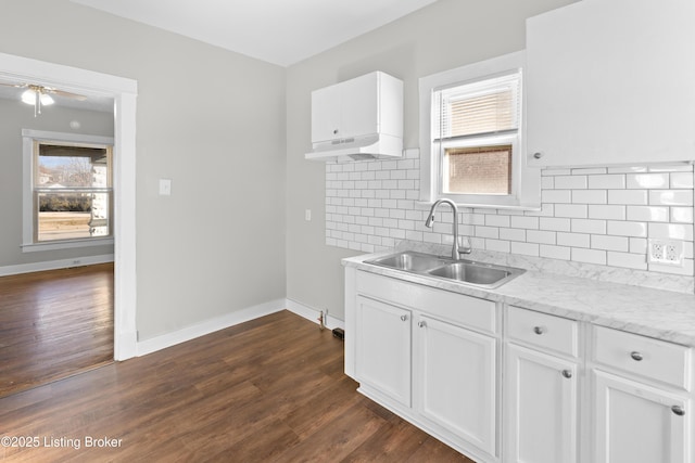 kitchen with a sink, baseboards, dark wood-style flooring, and white cabinetry