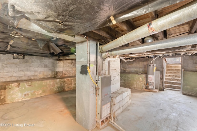 unfinished basement with stairway, heating unit, and water heater