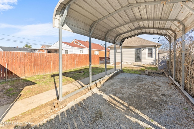 view of parking / parking lot featuring a carport and fence