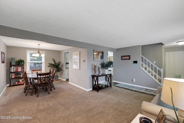 dining room with stairs, light colored carpet, baseboards, and a chandelier