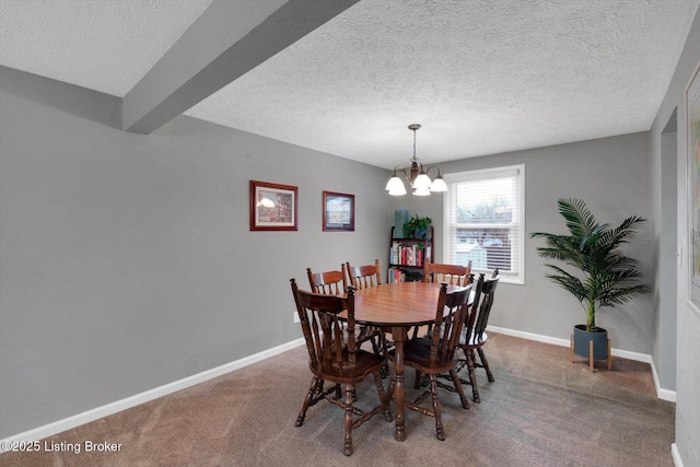 dining space with a textured ceiling, carpet, baseboards, and a chandelier