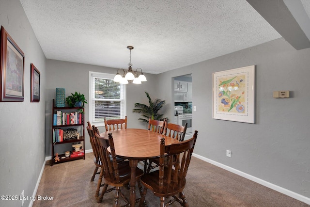 dining area featuring a notable chandelier, baseboards, carpet, and a textured ceiling