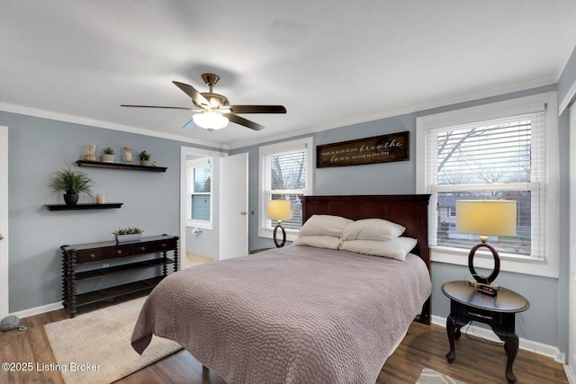 bedroom with crown molding, wood finished floors, and baseboards