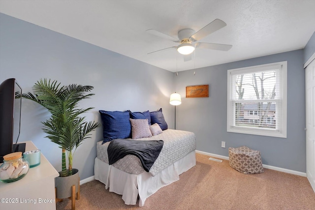 carpeted bedroom with visible vents, ceiling fan, and baseboards